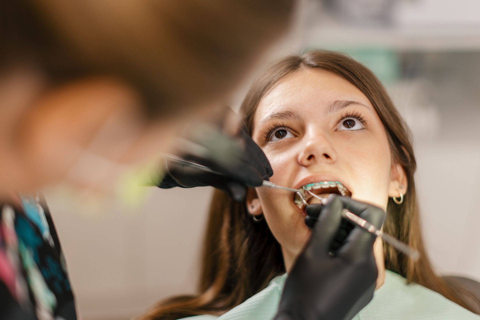 Teenage girl receiving braces treatment at a dentist’s office