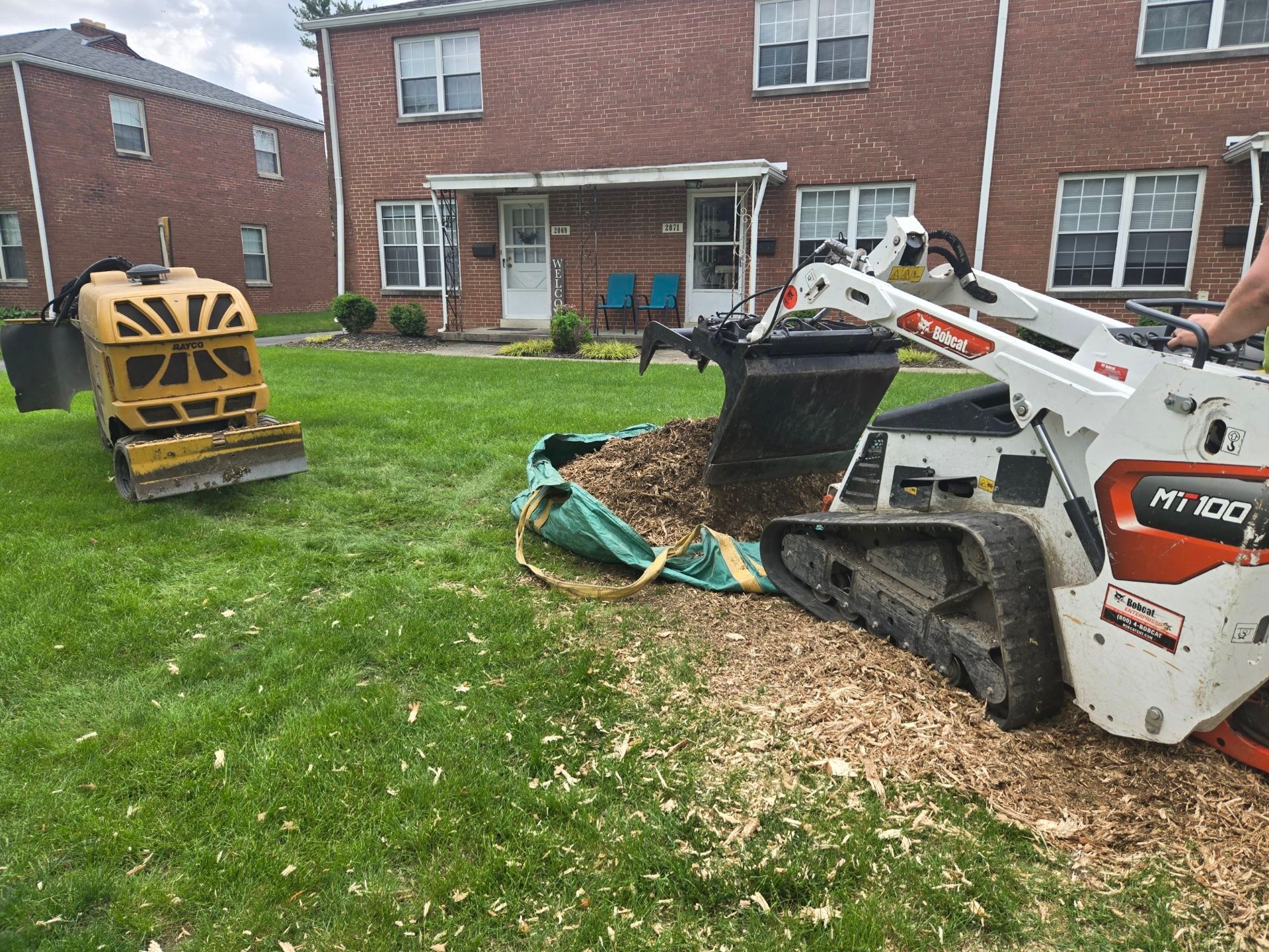 A man is using a bulldozer to remove a tree stump.
