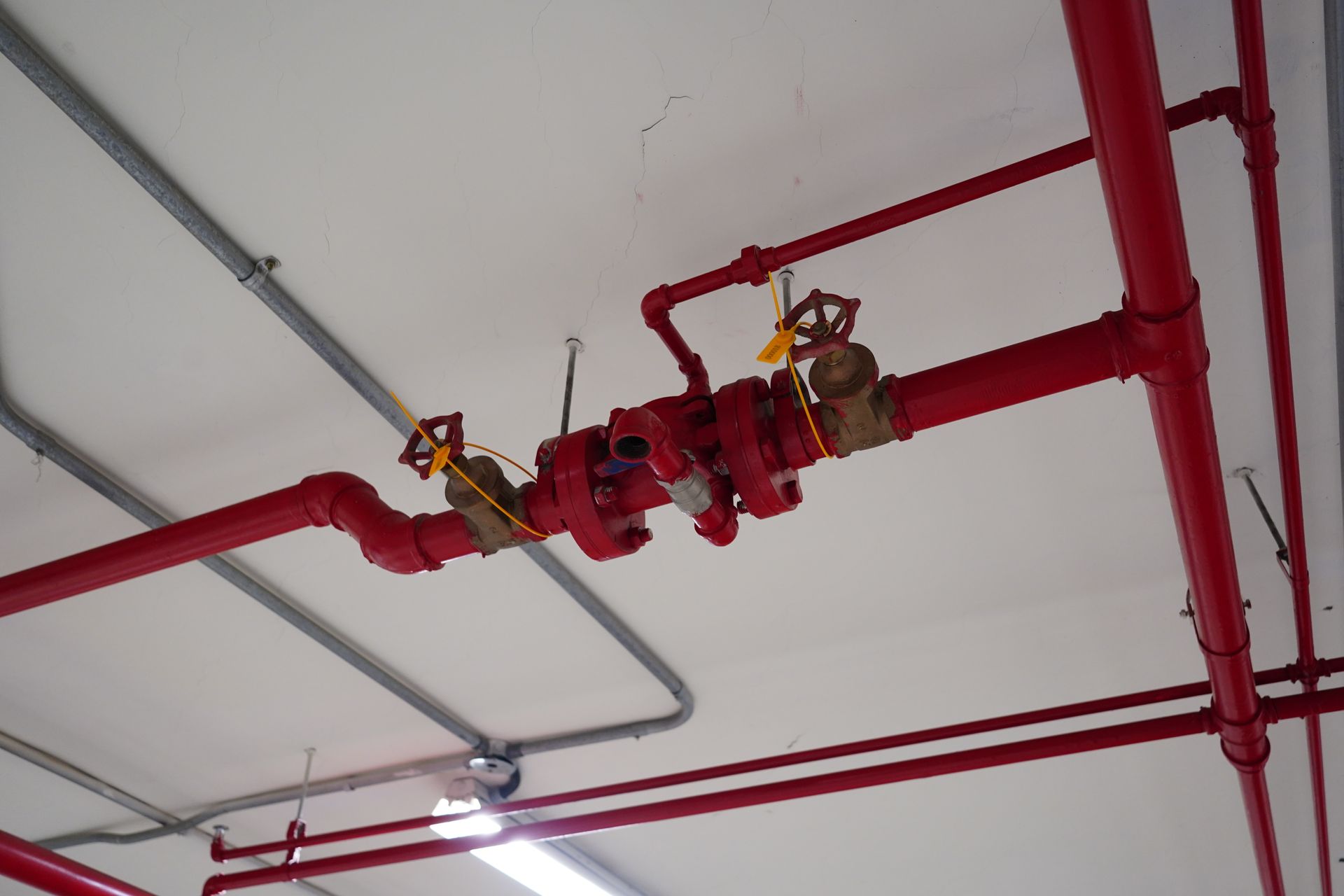 Industrial fire sprinkler system with red pipes and valves.
