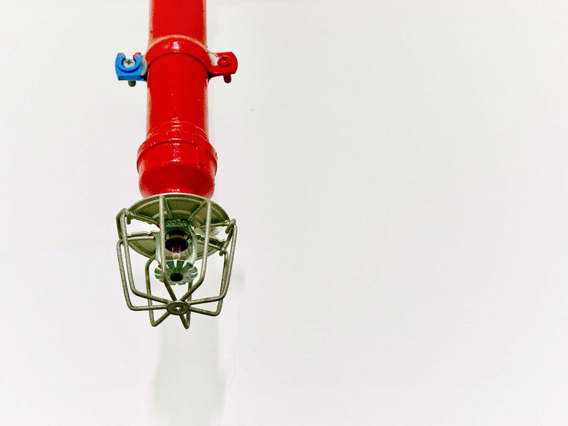 Close-up of red ceiling pipe with sprinkler head used during fire sprinkler system inspection. Close-up of red ceiling pipe with sprinkler head used during fire sprinkler system inspection.