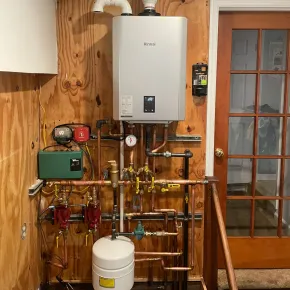 Apex Climate Control - A room with a boiler and copper pipes on the wall.