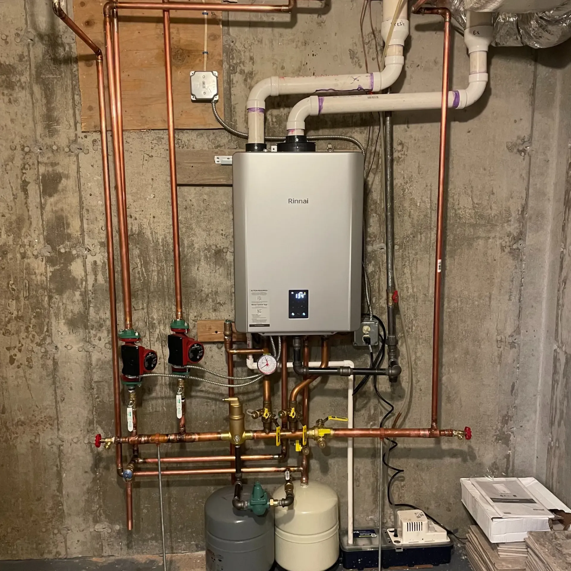Apex Climate Control - A water heater is surrounded by copper pipes and a propane tank