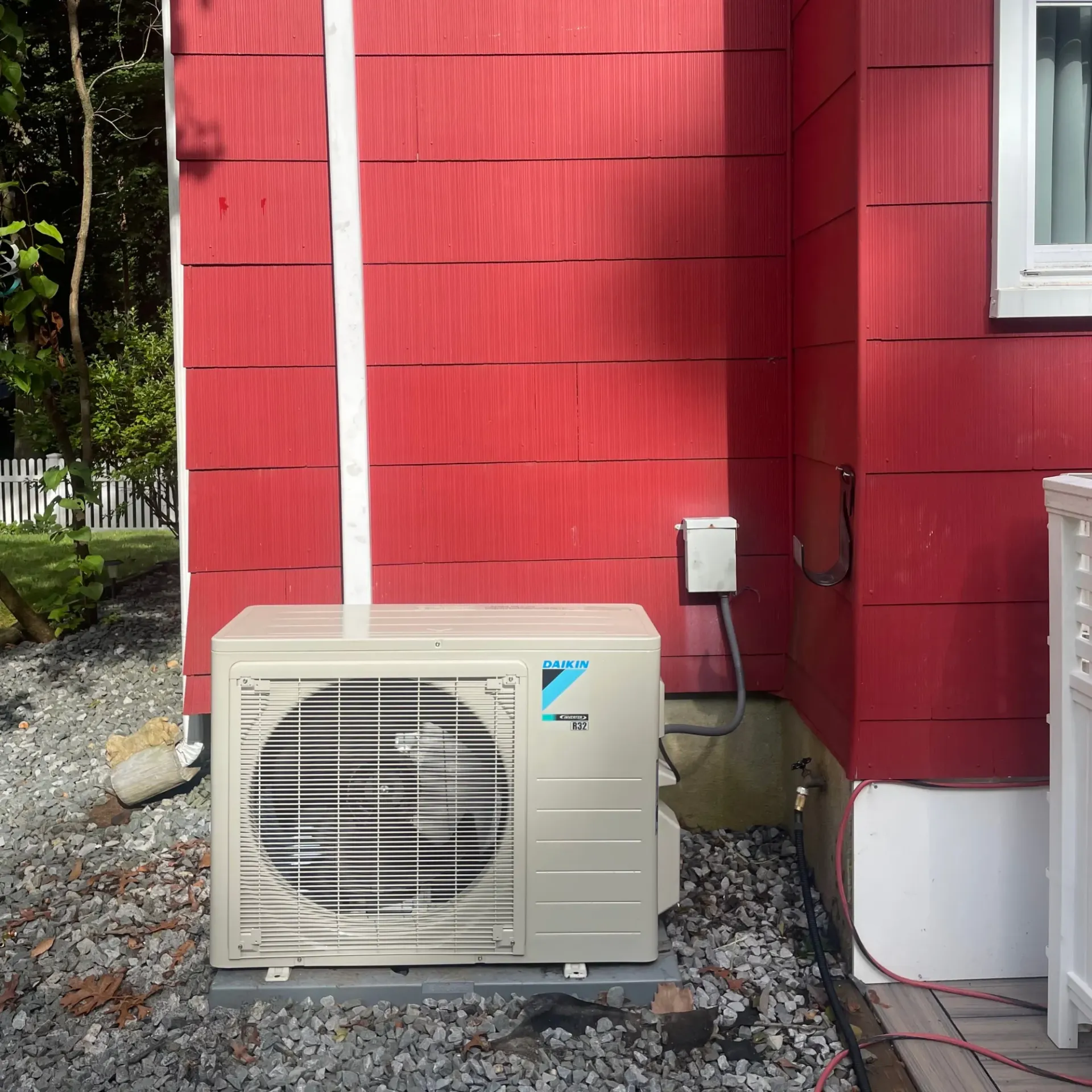 Apex Climate Control - A white daikin air conditioner is mounted on the side of a red house