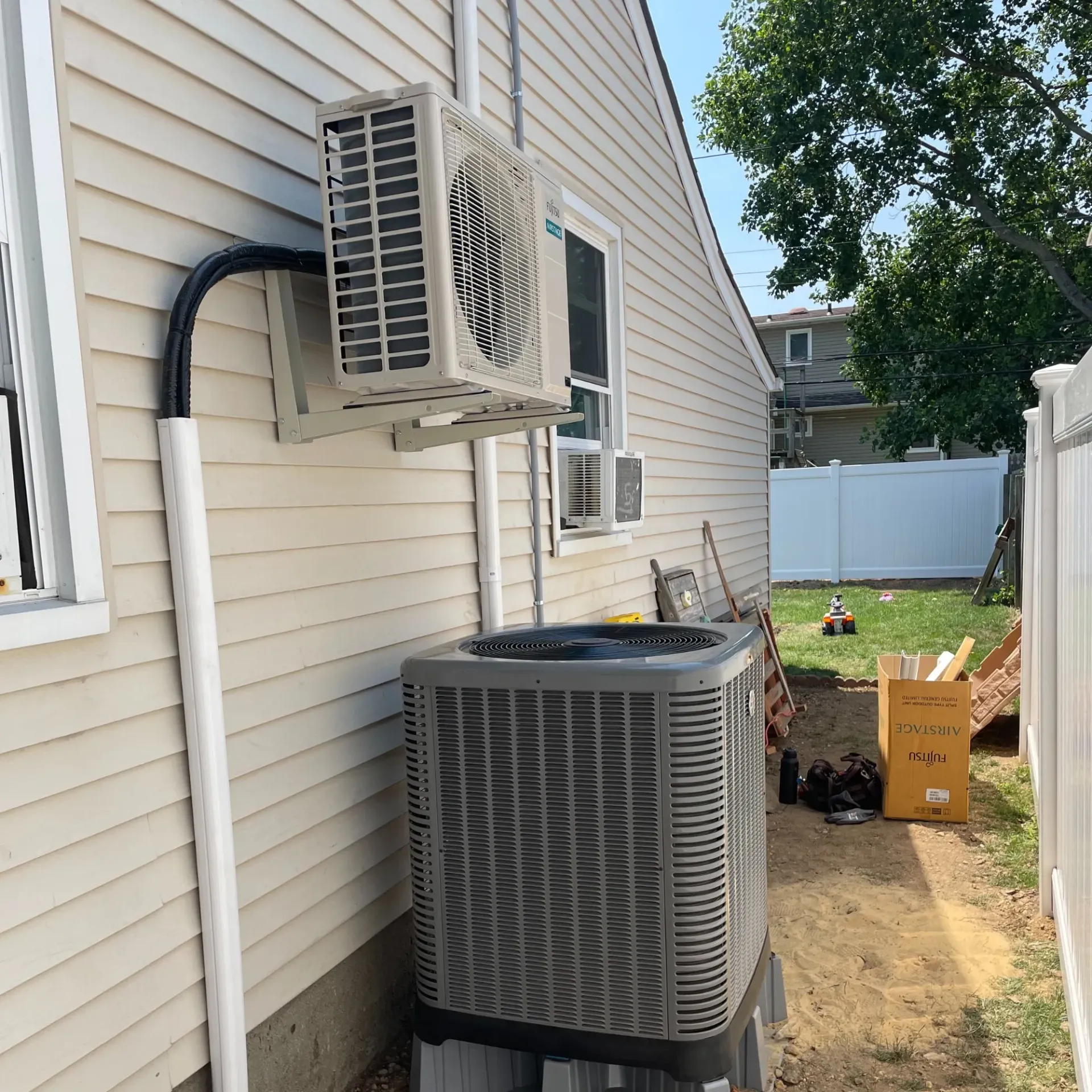 Apex Climate Control - An air conditioner is mounted on the side of a house