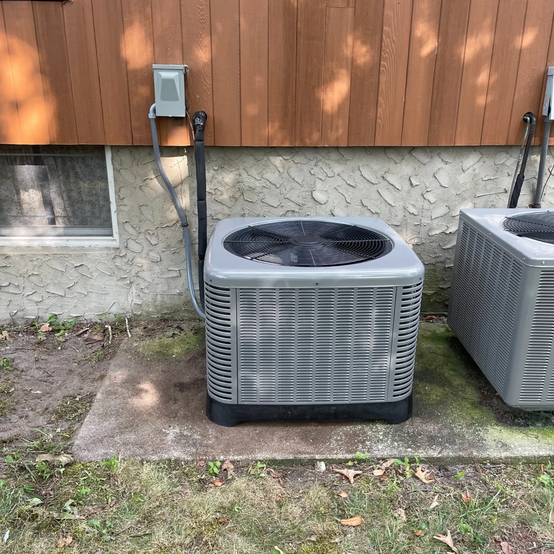 Apex Climate Control - Two air conditioners are sitting outside of a house.