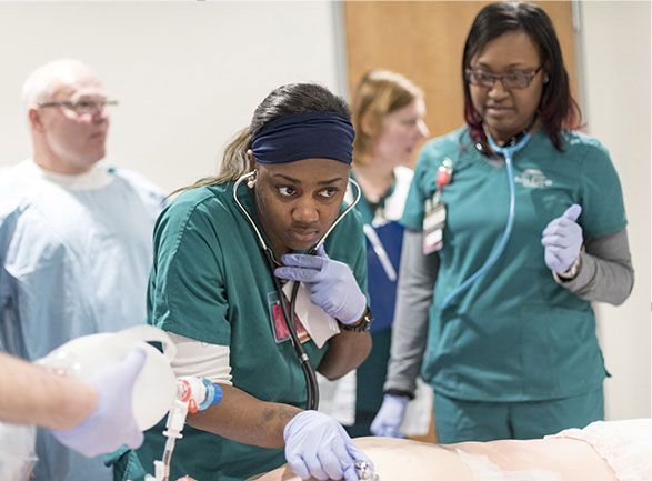 A nurse is using a stethoscope to listen to a patient 's heartbeat.