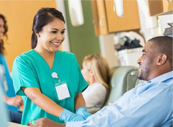 A nurse is talking to a patient in a hospital room.