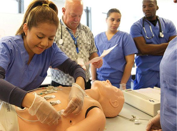 A group of nurses are working on a mannequin.