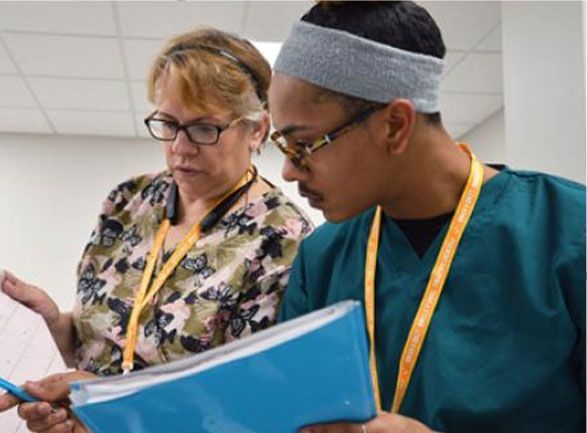A man and a woman are looking at a blue folder.