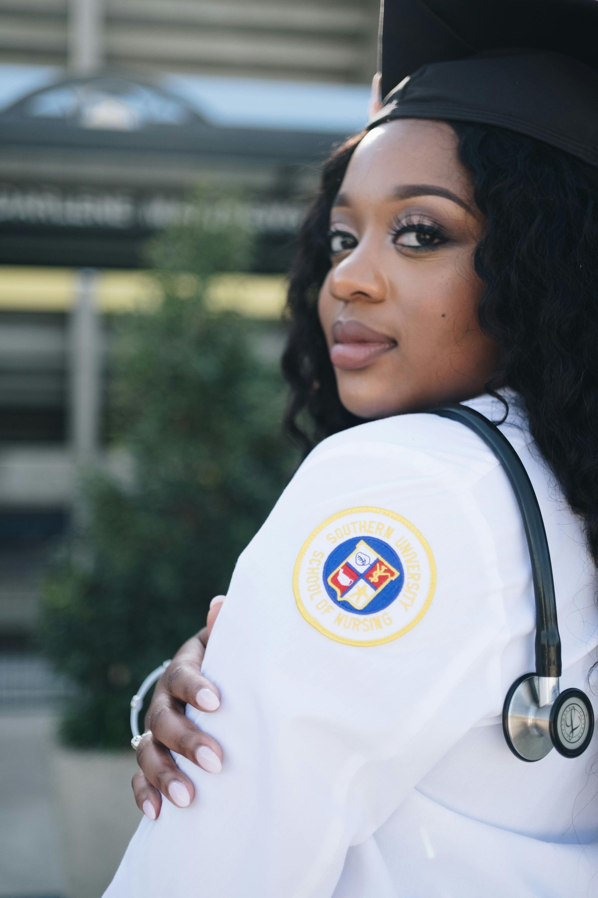 A woman in a graduation cap and gown with a stethoscope around her neck.