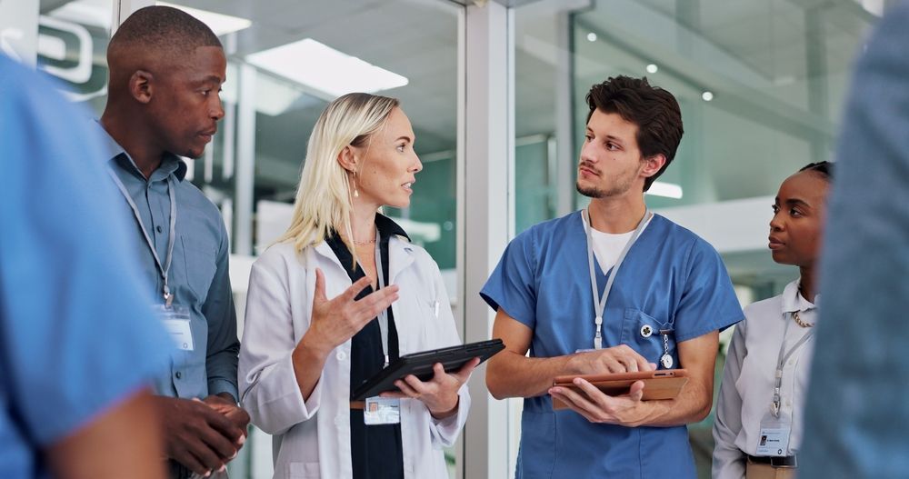 A group of doctors and nurses are talking to each other in a hospital.