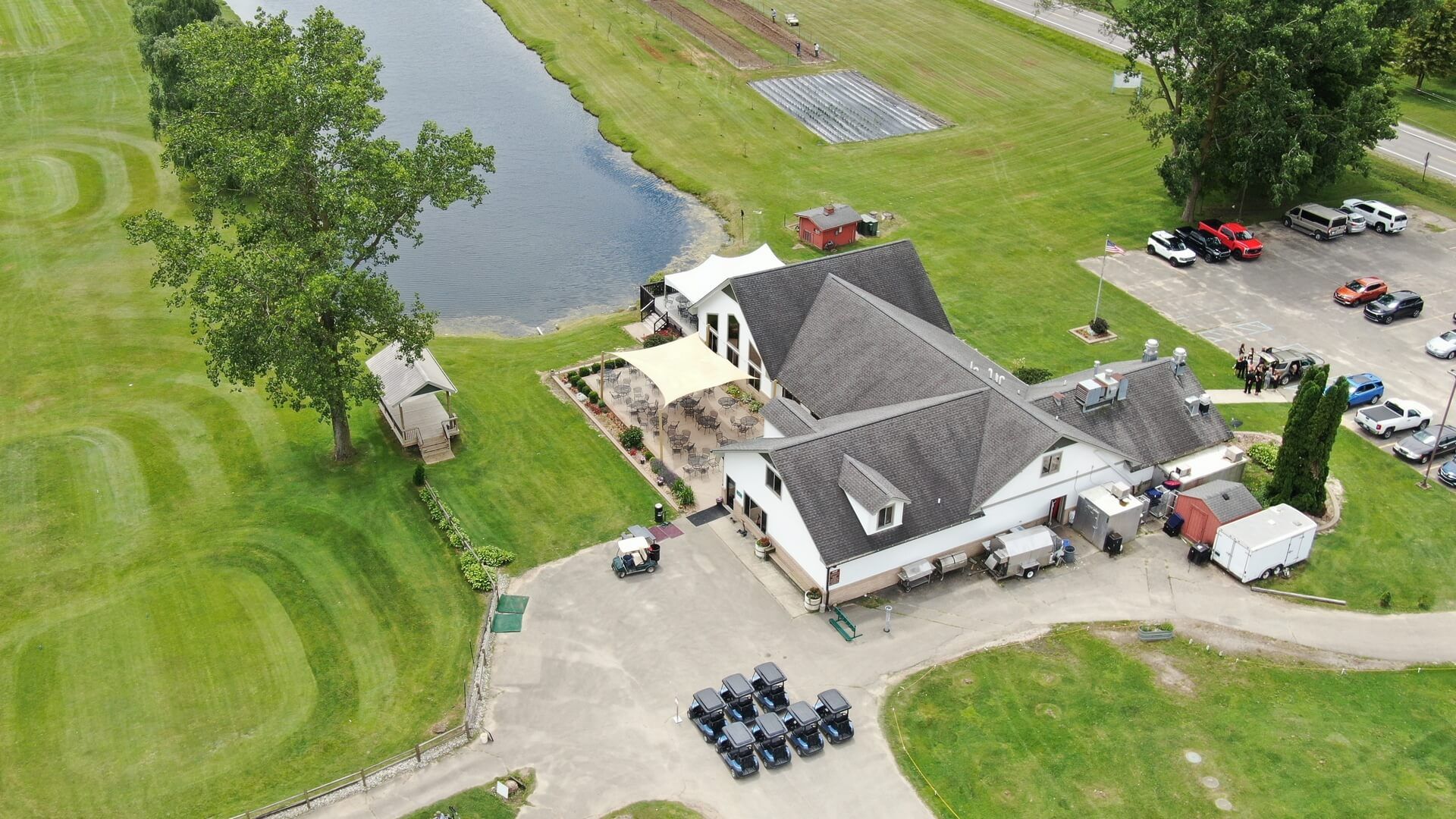An aerial view of a golf course with a house in the middle of it.