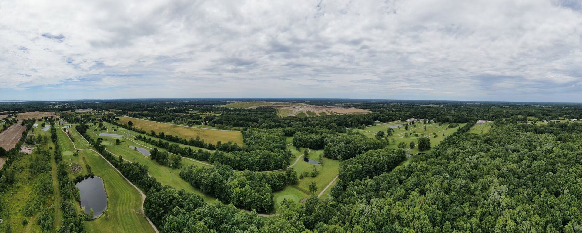 An aerial view of a golf course surrounded by trees and fields.