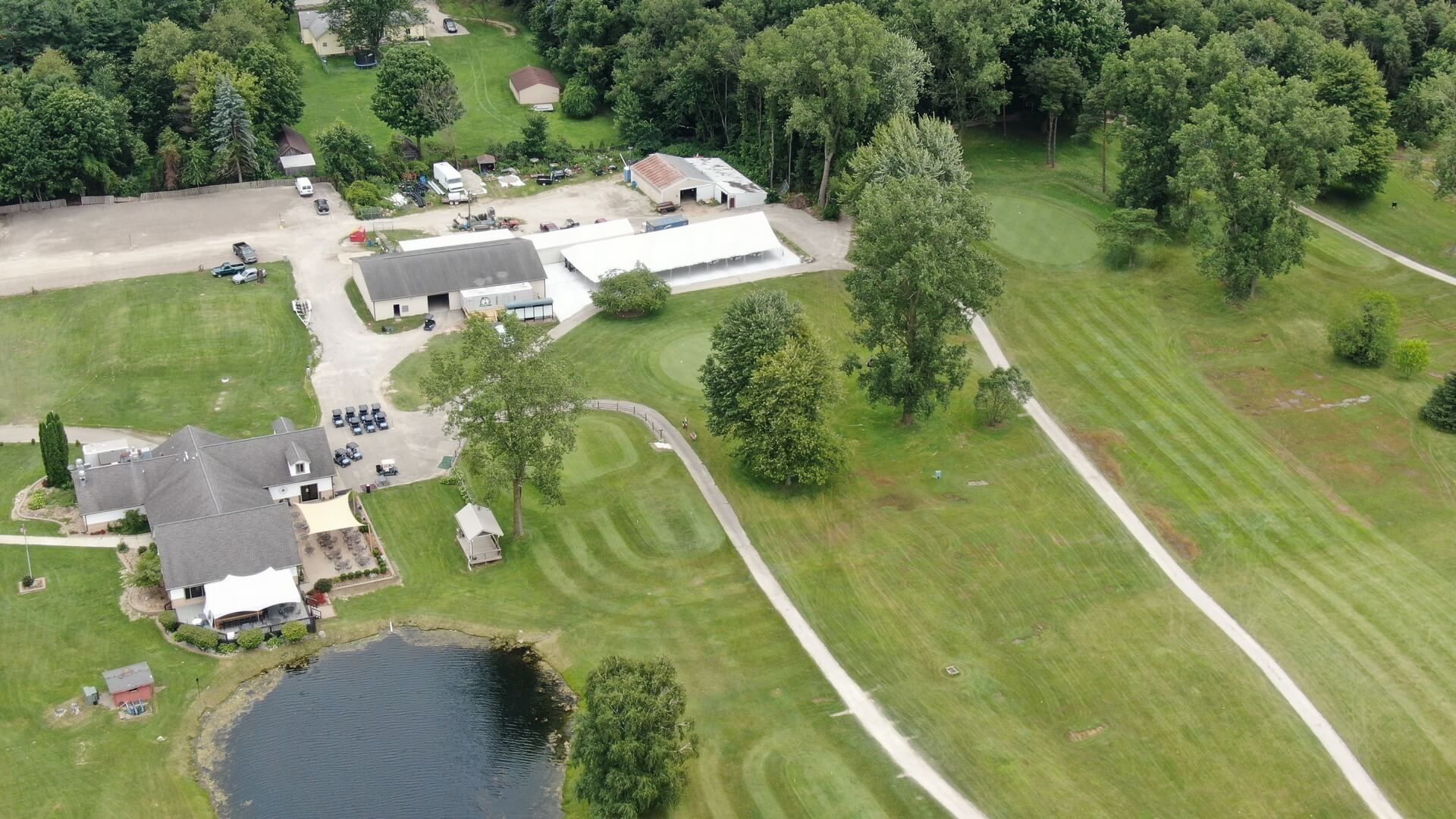 An aerial view of a golf course surrounded by trees and grass.