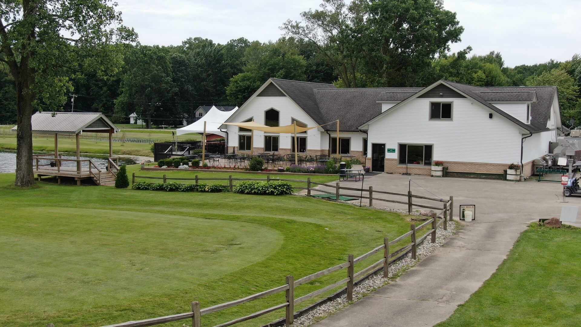 A large white house is sitting on top of a lush green field.