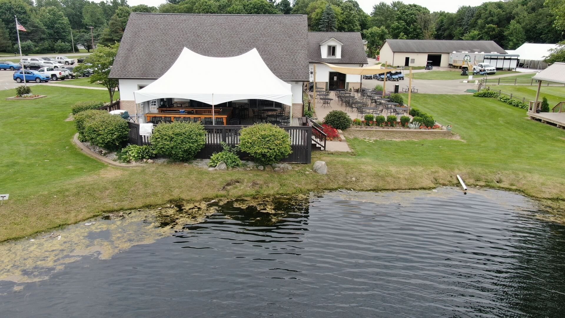 An aerial view of a house with a pond in front of it.