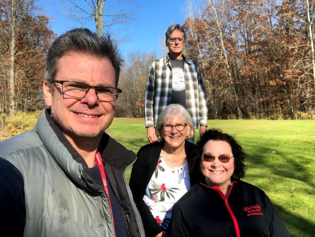 A group of people posing for a picture in a field.