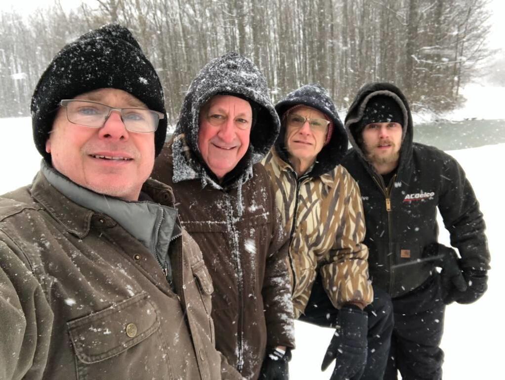 A group of men are posing for a picture in the snow.