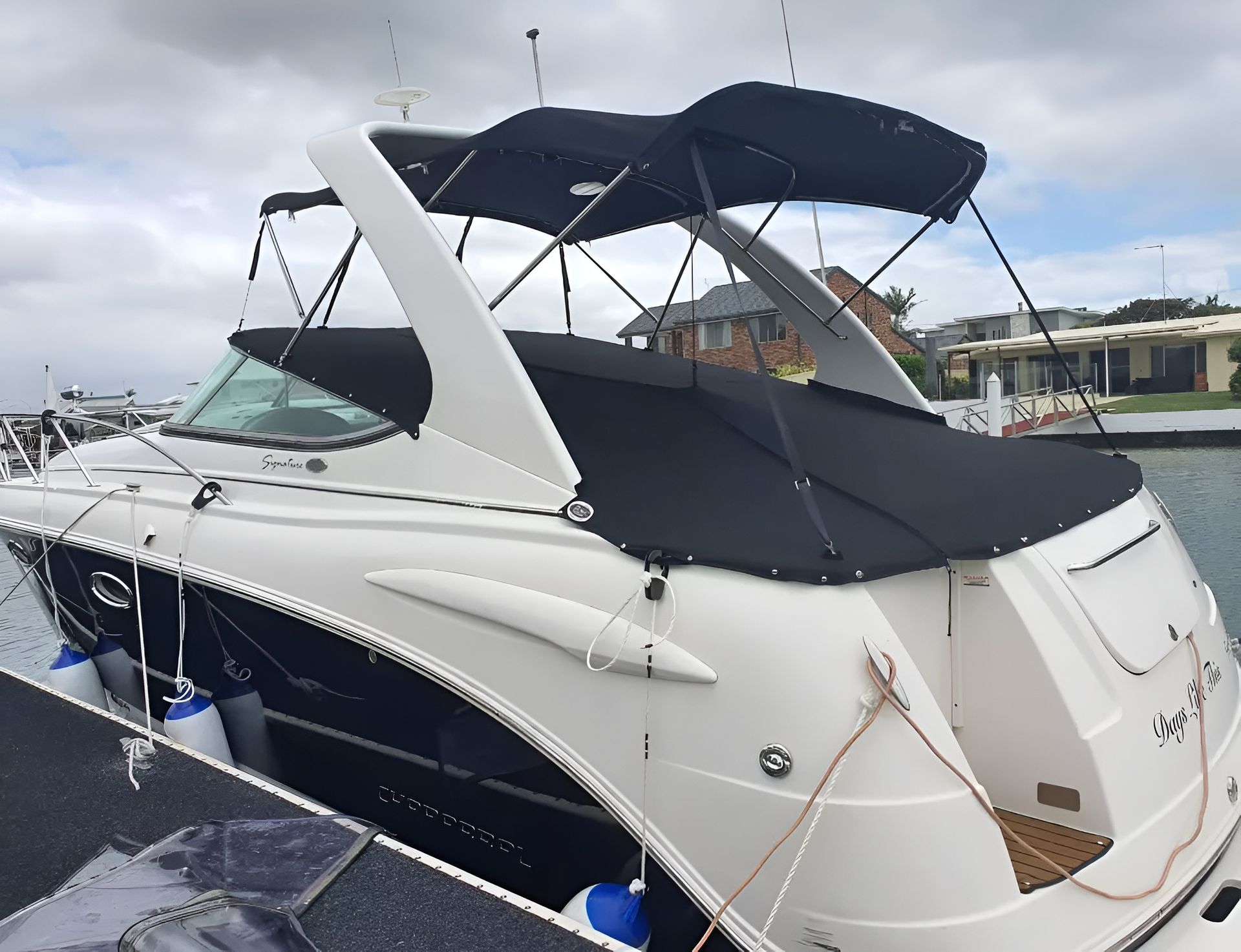 White and Blue Boat Docked at a Pier, Covered With a Black Canopy — The Boat Cover Company In Buddina, QLD