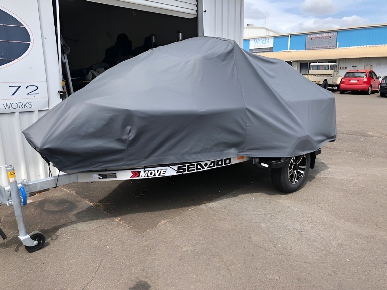 Boat Covered With a Gray Tarp on a Trailer, Parked Outside a Building — The Boat Cover Company In Buddina, QLD