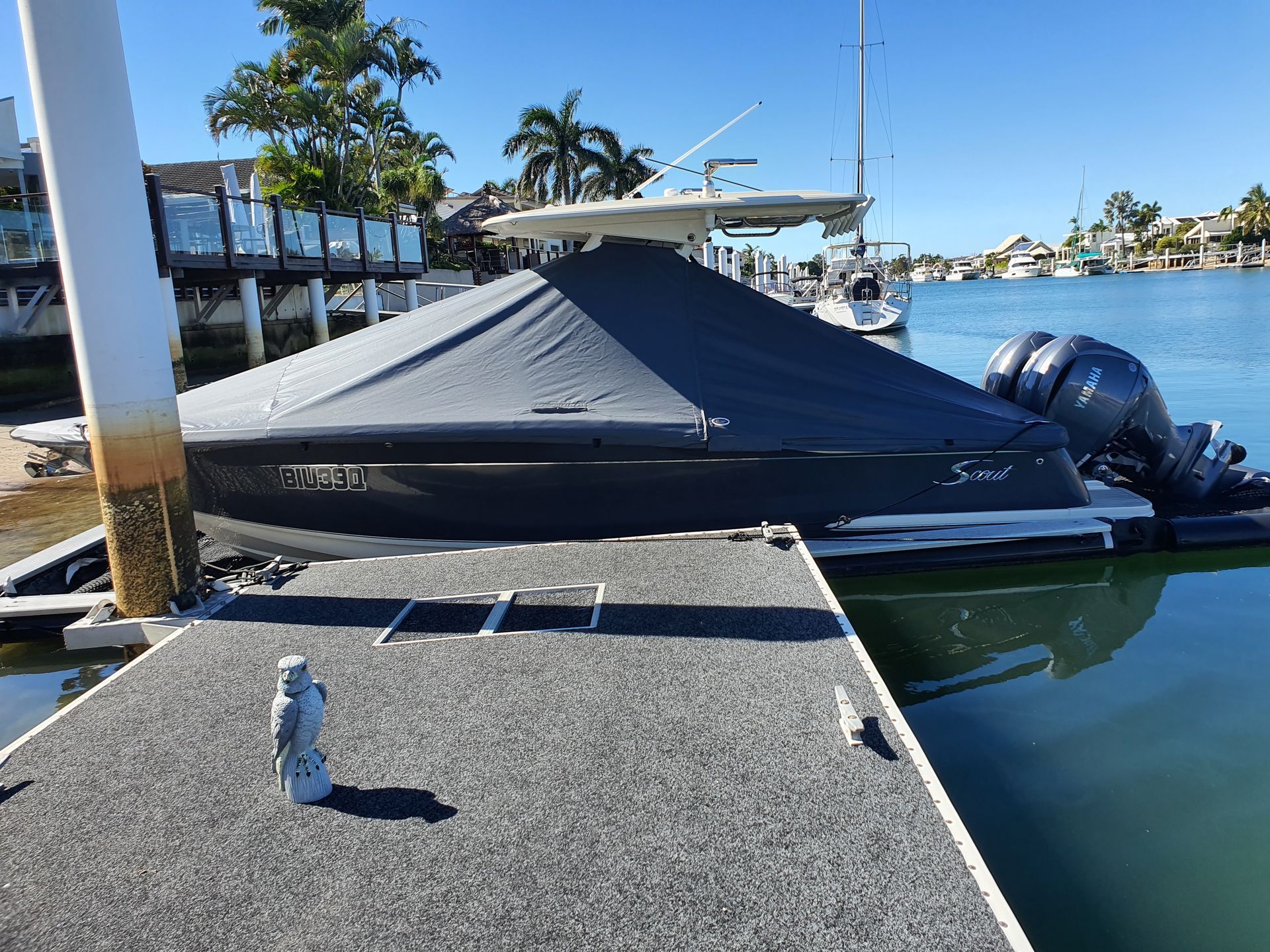 A boat is docked at a dock next to a body of water. The Boat Cover Company In Buddina, QLD