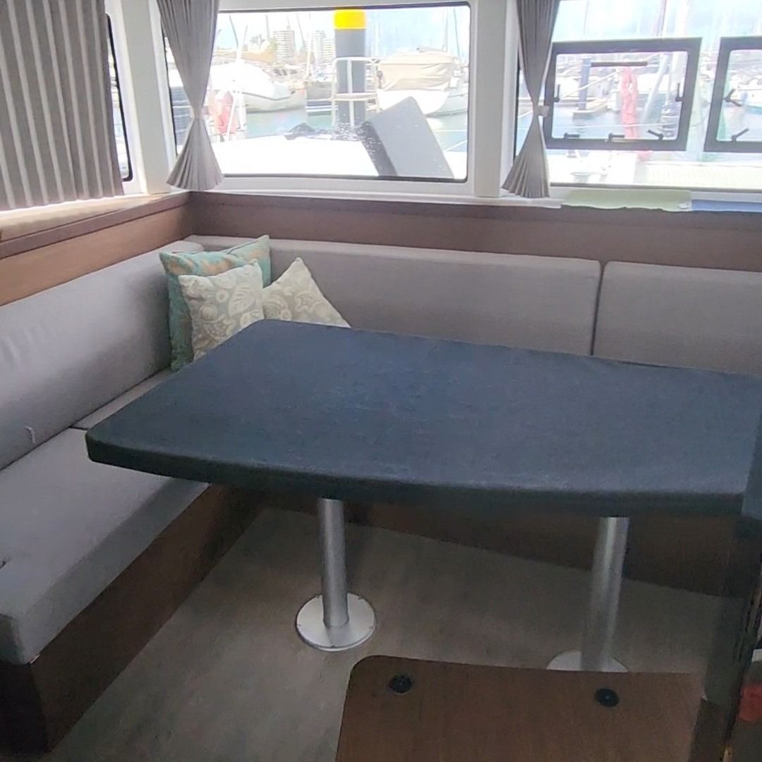 Boat Cabin Interior With a Table, Seating, and Windows Overlooking a Harbor — The Boat Cover Company In Buddina, QLD