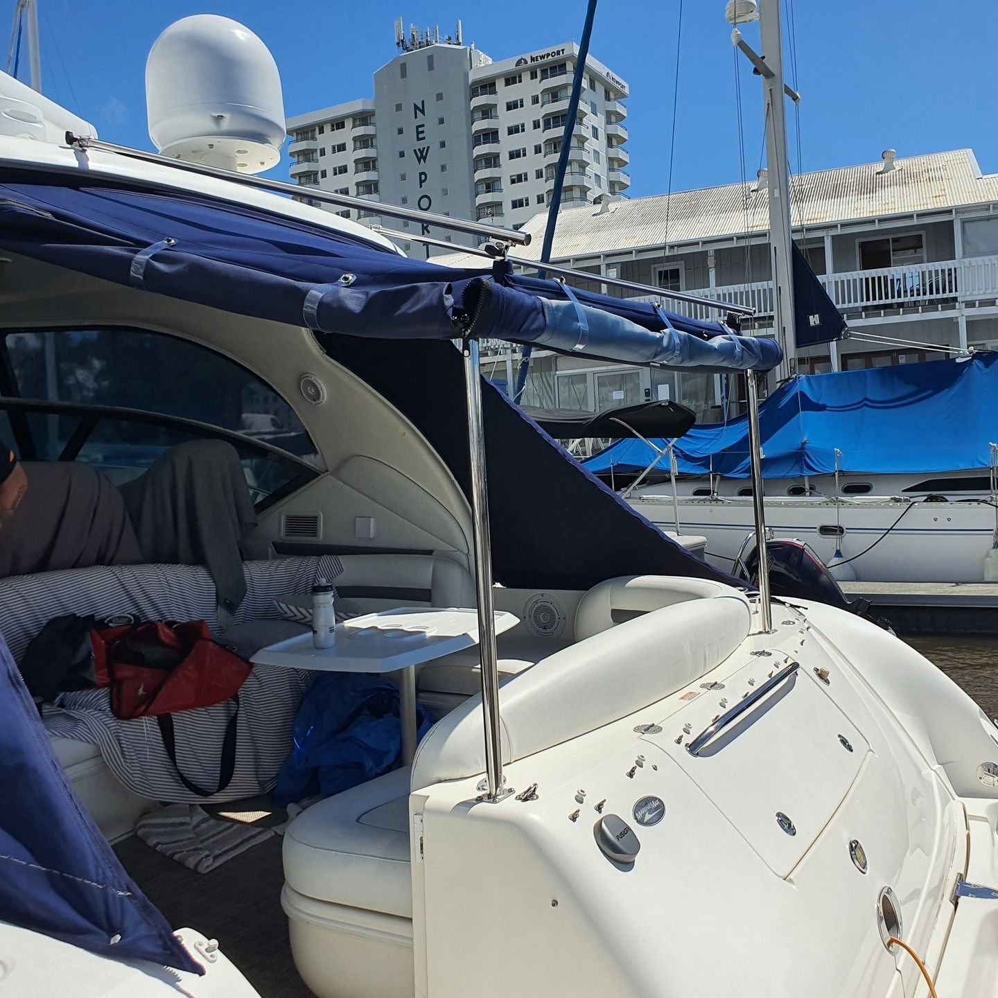 A Yacht's Stern With a Blue Canopy, Small Table, and Antenna — The Boat Cover Company In Buddina, QLD