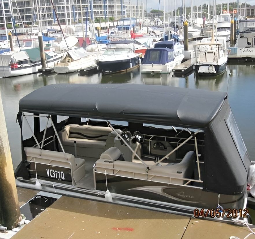 Pontoon Boat With Black Canopy Docked at a Marina — The Boat Cover Company In Buddina, QLD