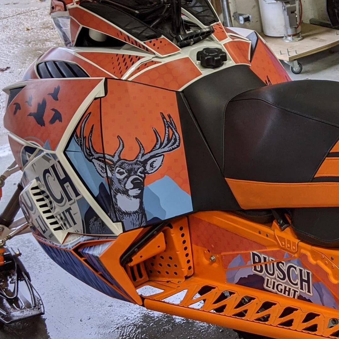 A busch light snowmobile with a deer on the side