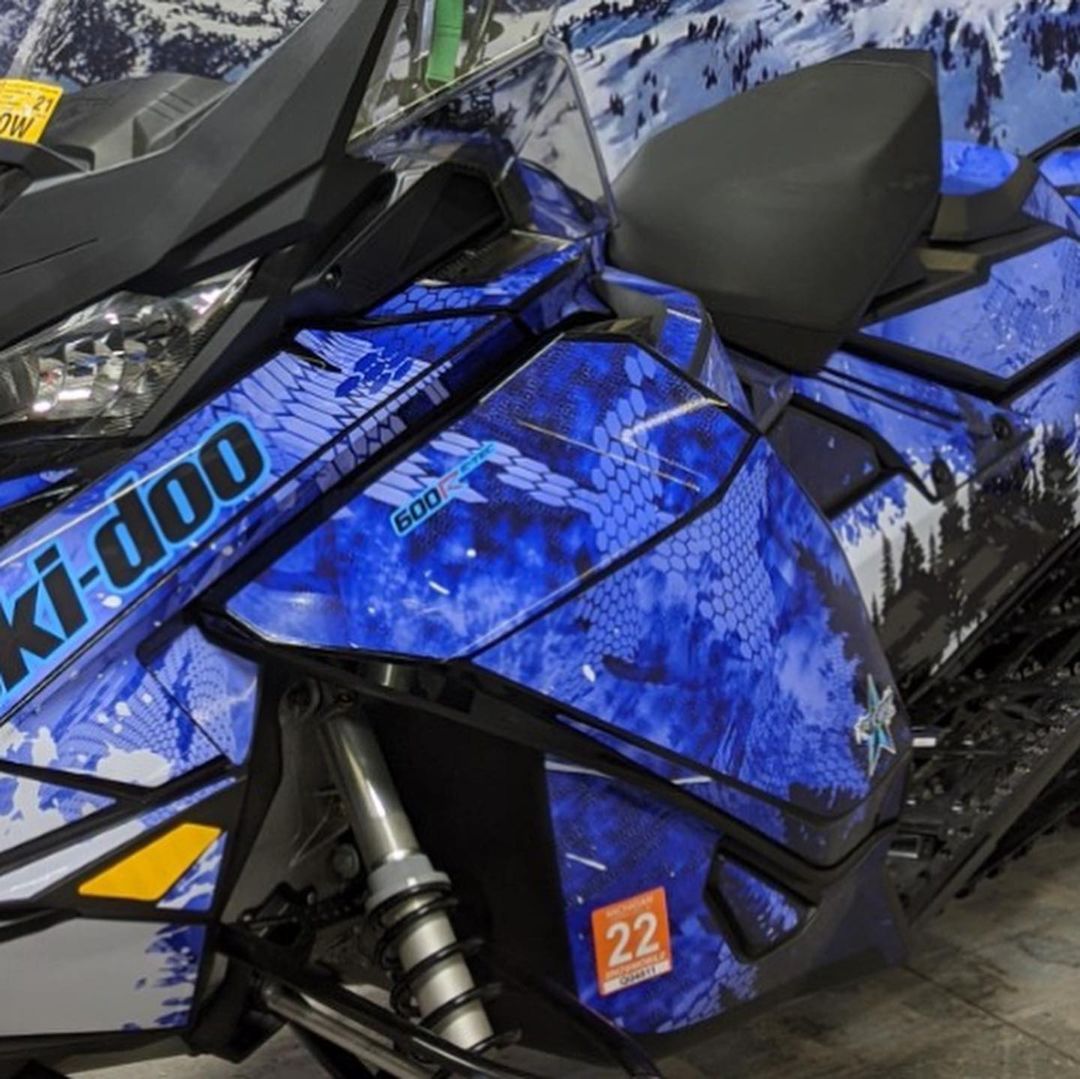 A blue snowmobile with the word ki-doo on it