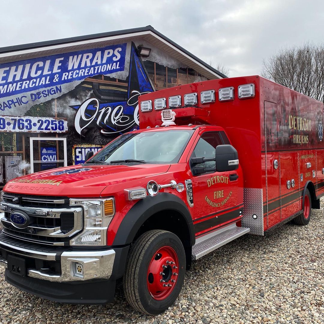 A red ambulance is parked in front of a building.