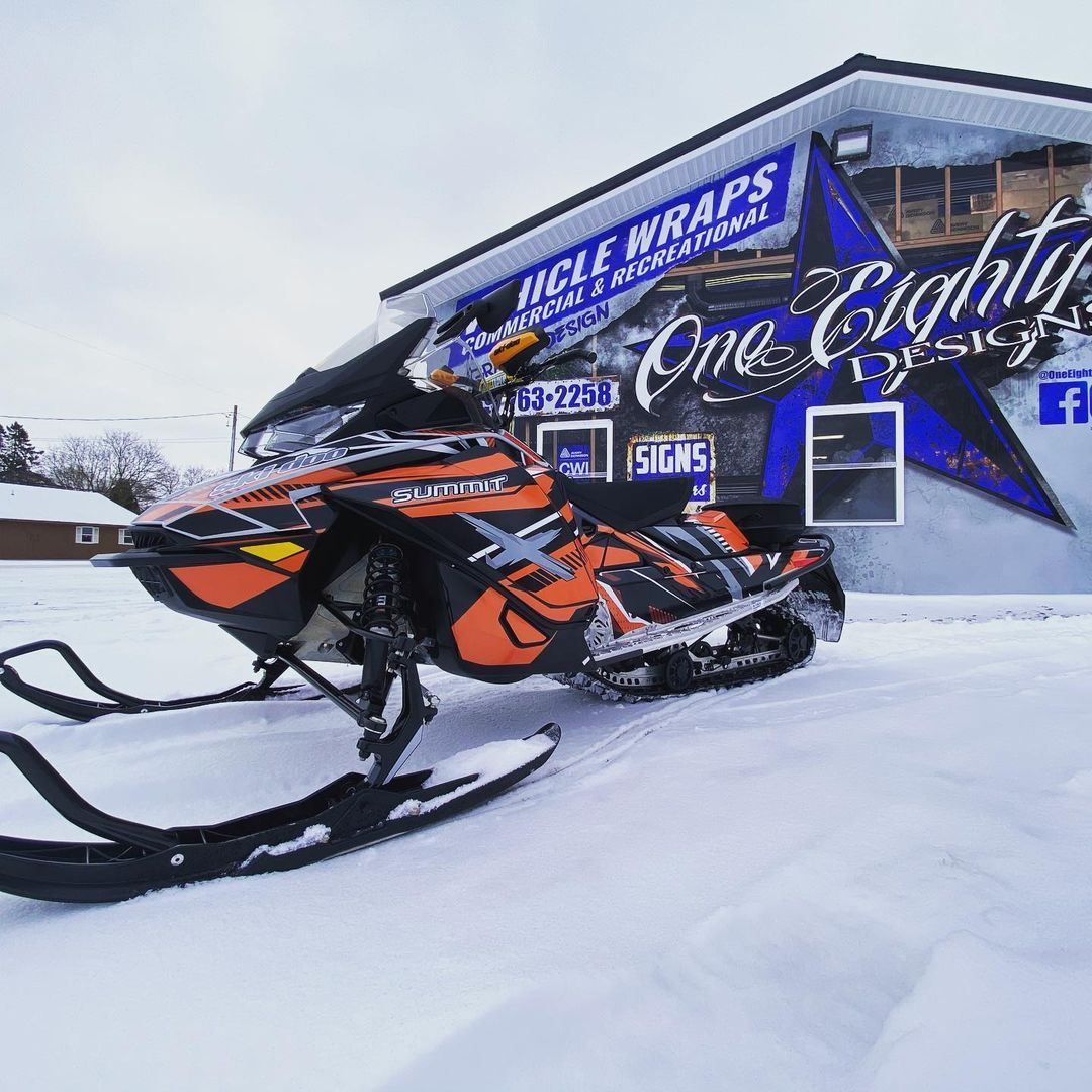 A snowmobile is parked in front of a building.