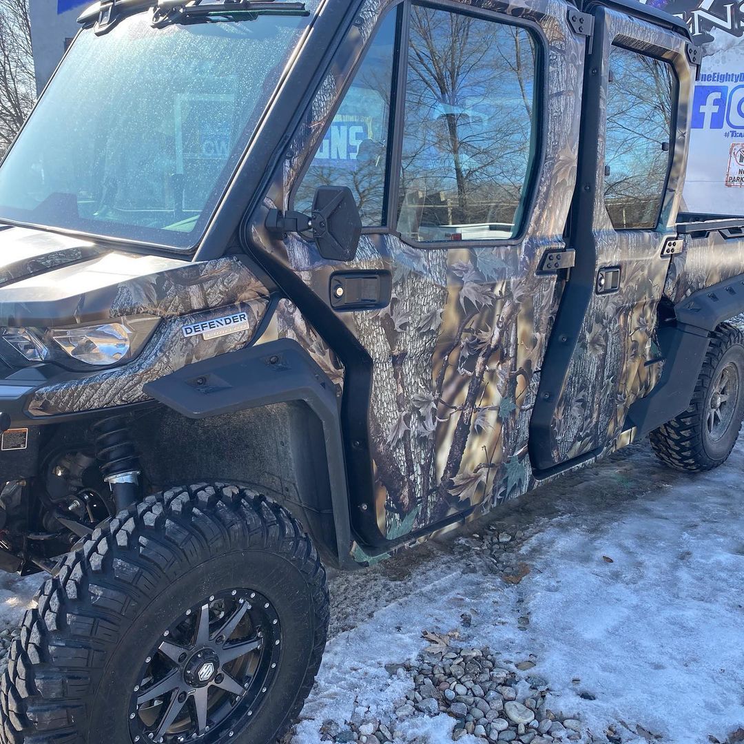 A camouflaged vehicle is parked in the snow.