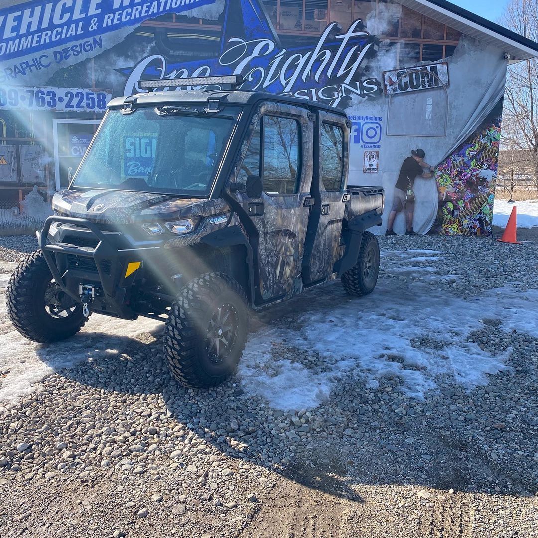 A vehicle is parked in front of a building in the snow.