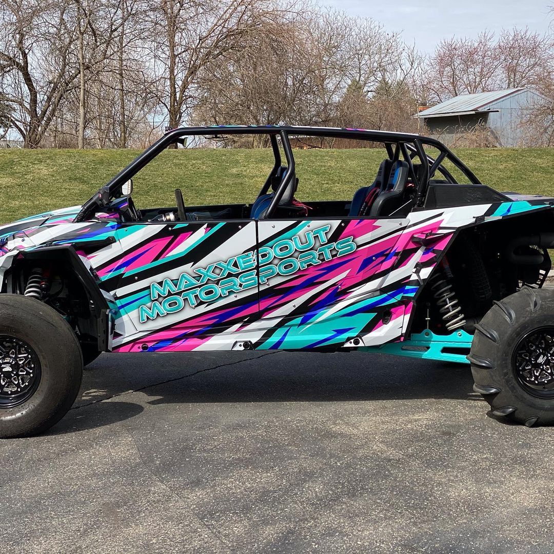 A colorful atv is parked on the side of the road.