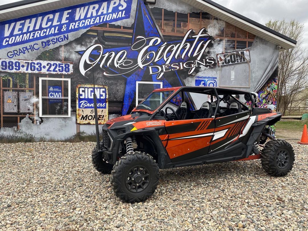 A red atv is parked in front of a building.