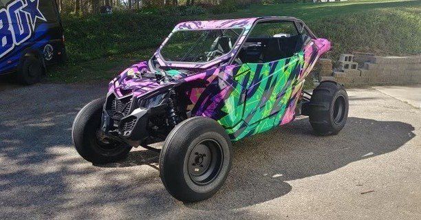 A colorful atv is parked on the side of the road.