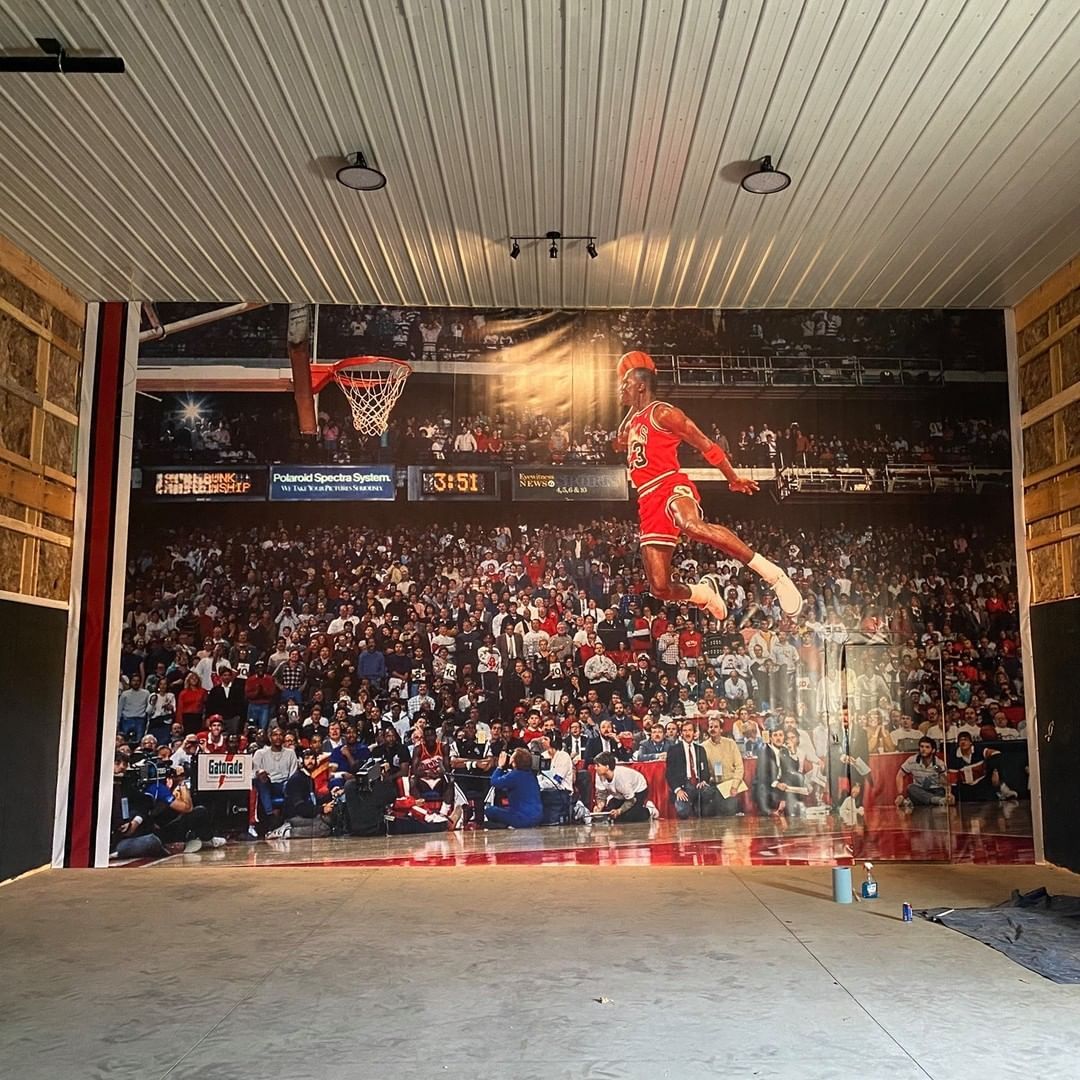 A large mural of michael jordan is hanging on a wall