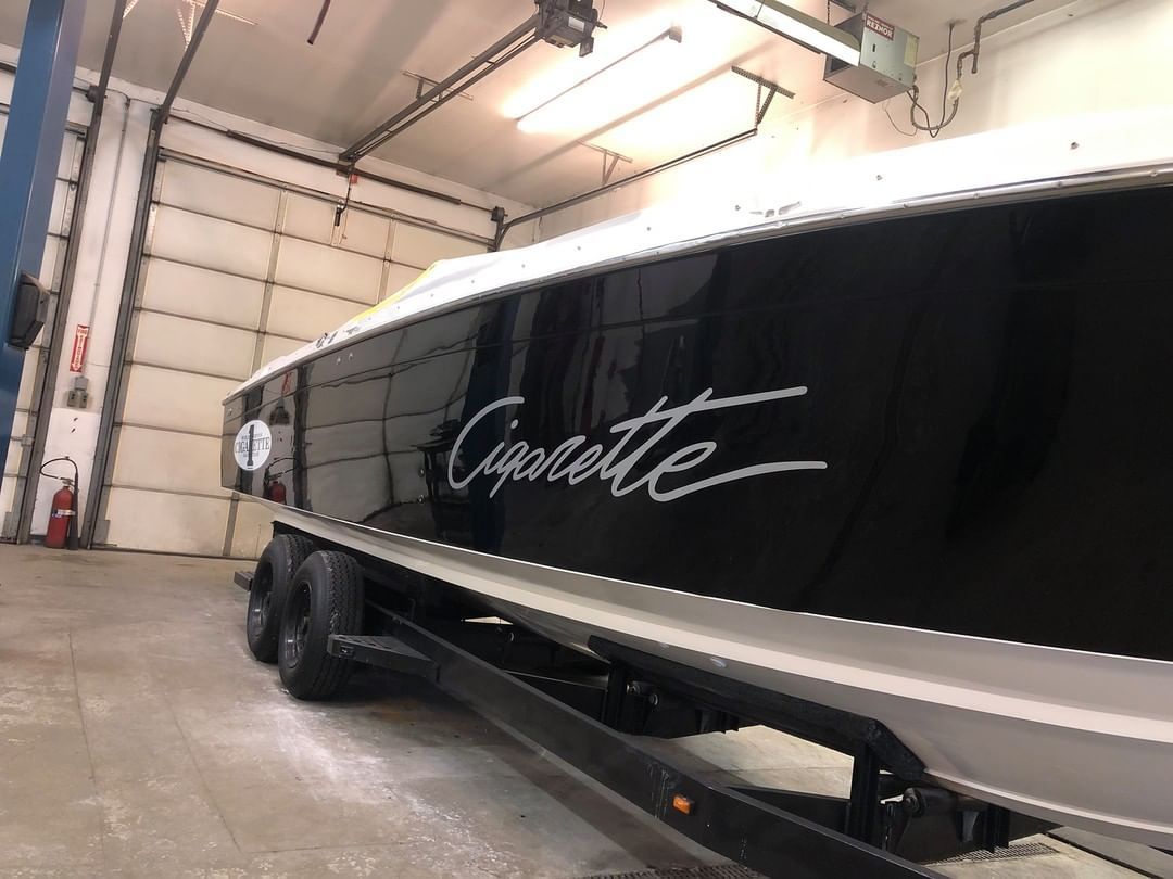 A black and white boat is parked in a garage.