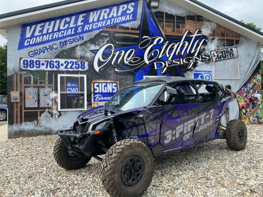 A purple atv is parked in front of a building.
