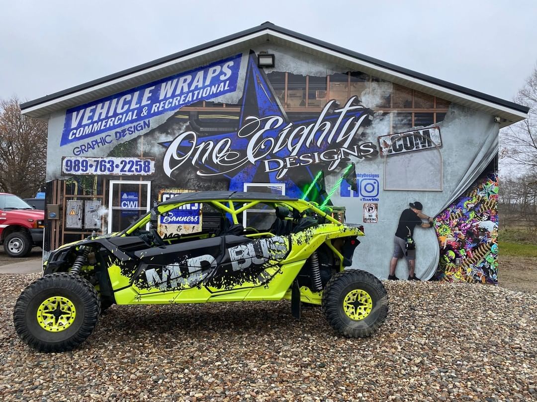 A yellow and black atv is parked in front of a building.
