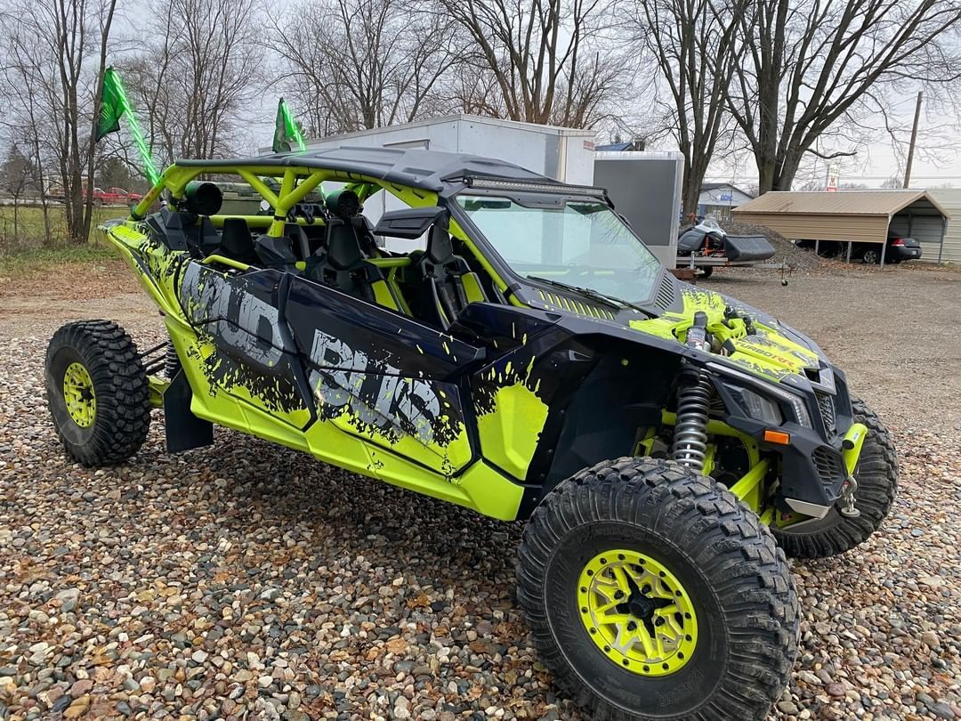 A yellow and black atv is parked on a gravel road.