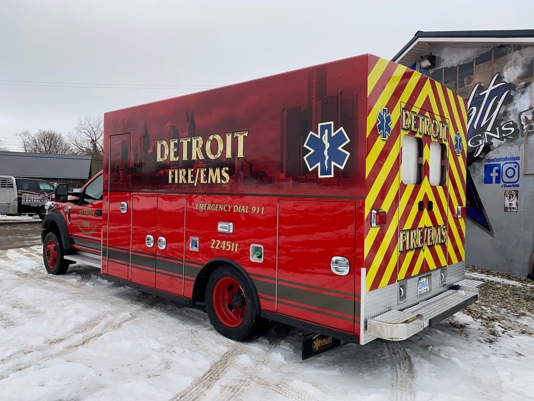 A red fire truck is parked in the snow in front of a building.