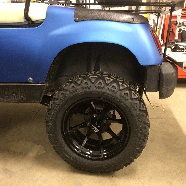 A blue golf cart is parked in a garage