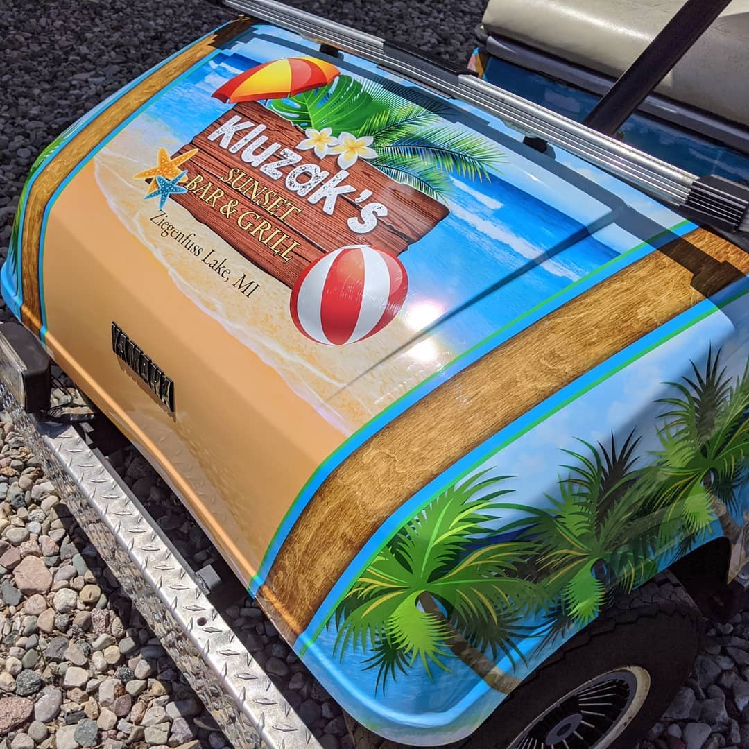 A golf cart with a beach scene painted on it.