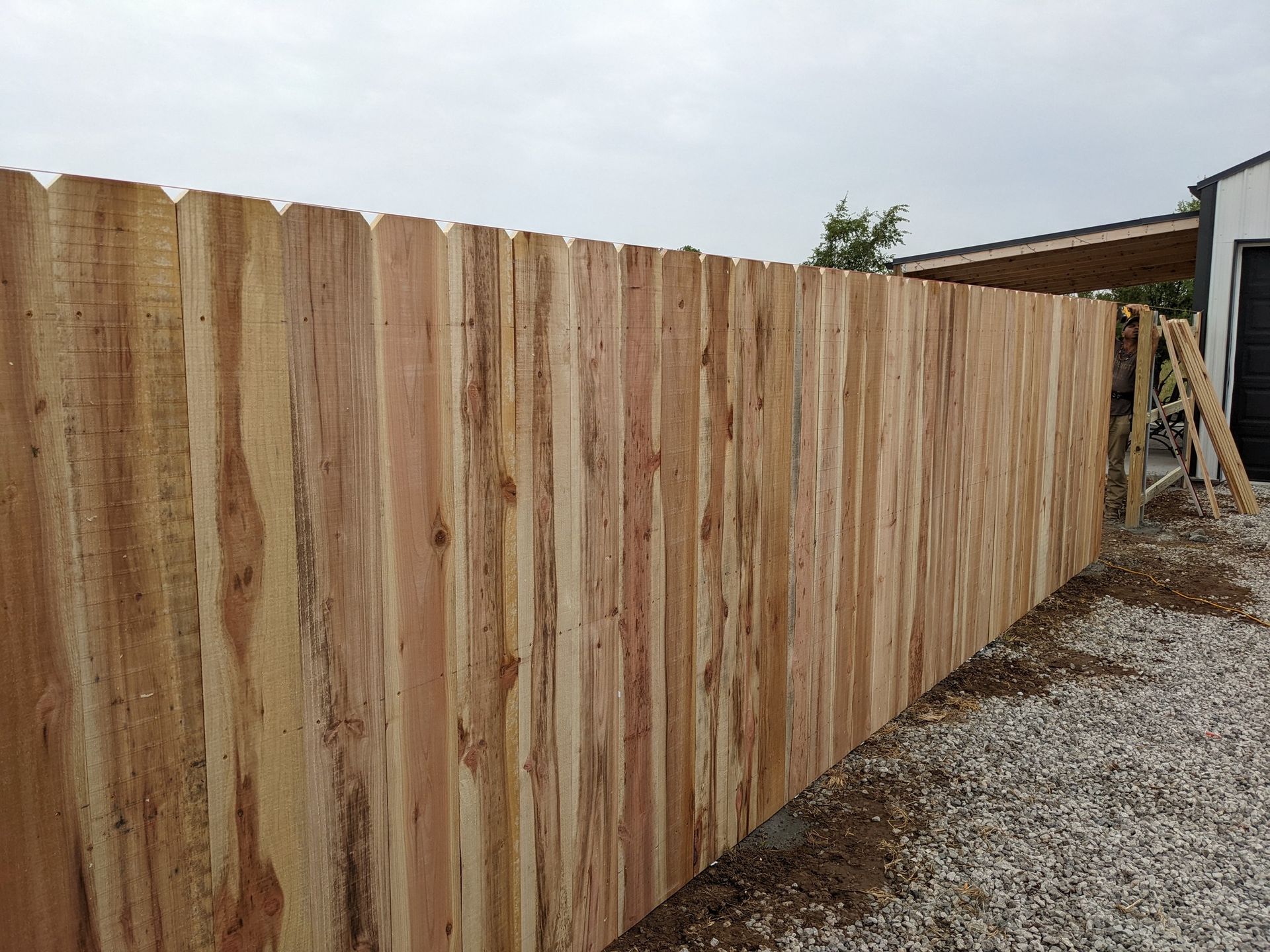 A wooden fence is being built in front of a house.