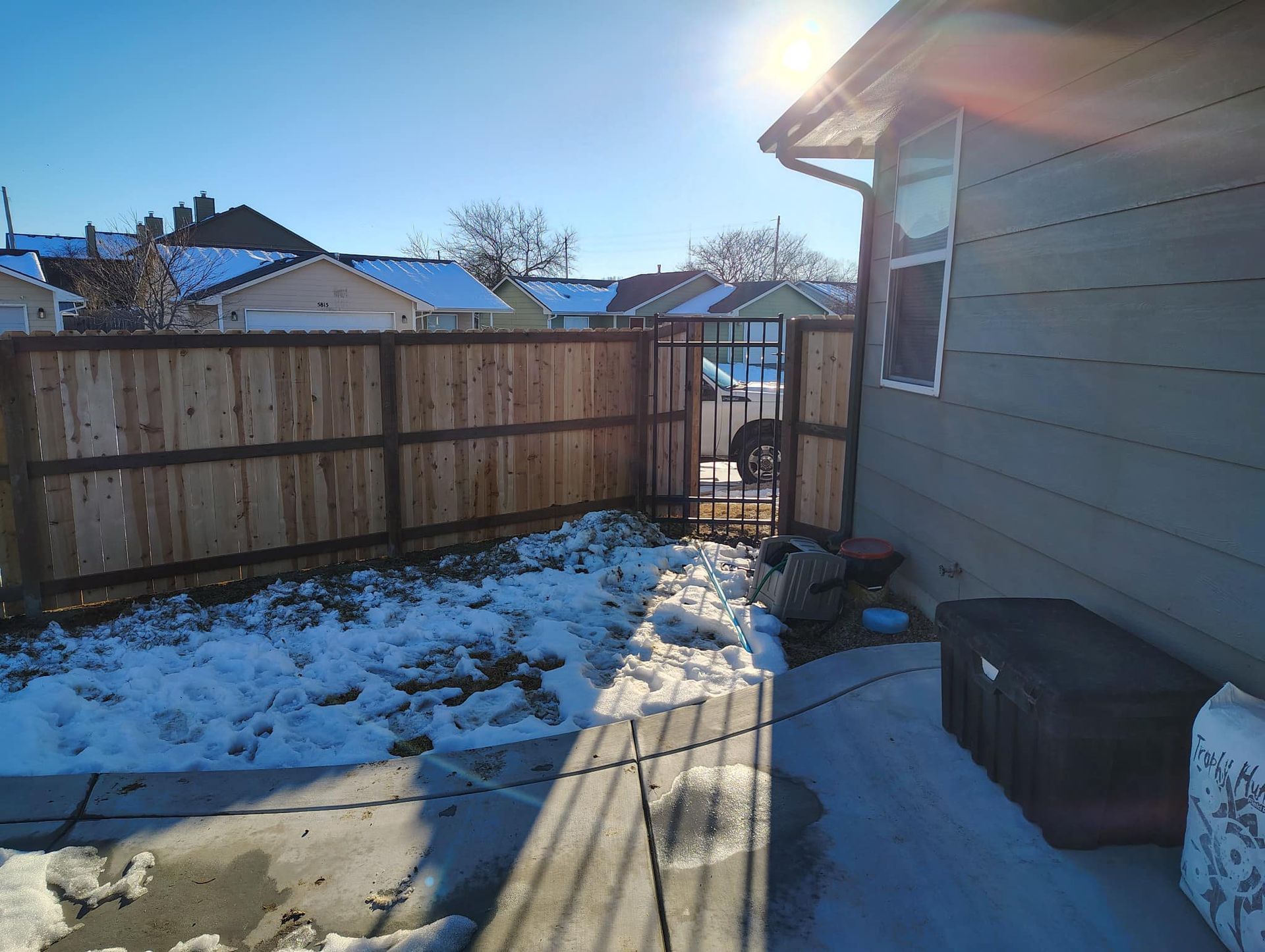 There is a wooden fence in the backyard of a house.