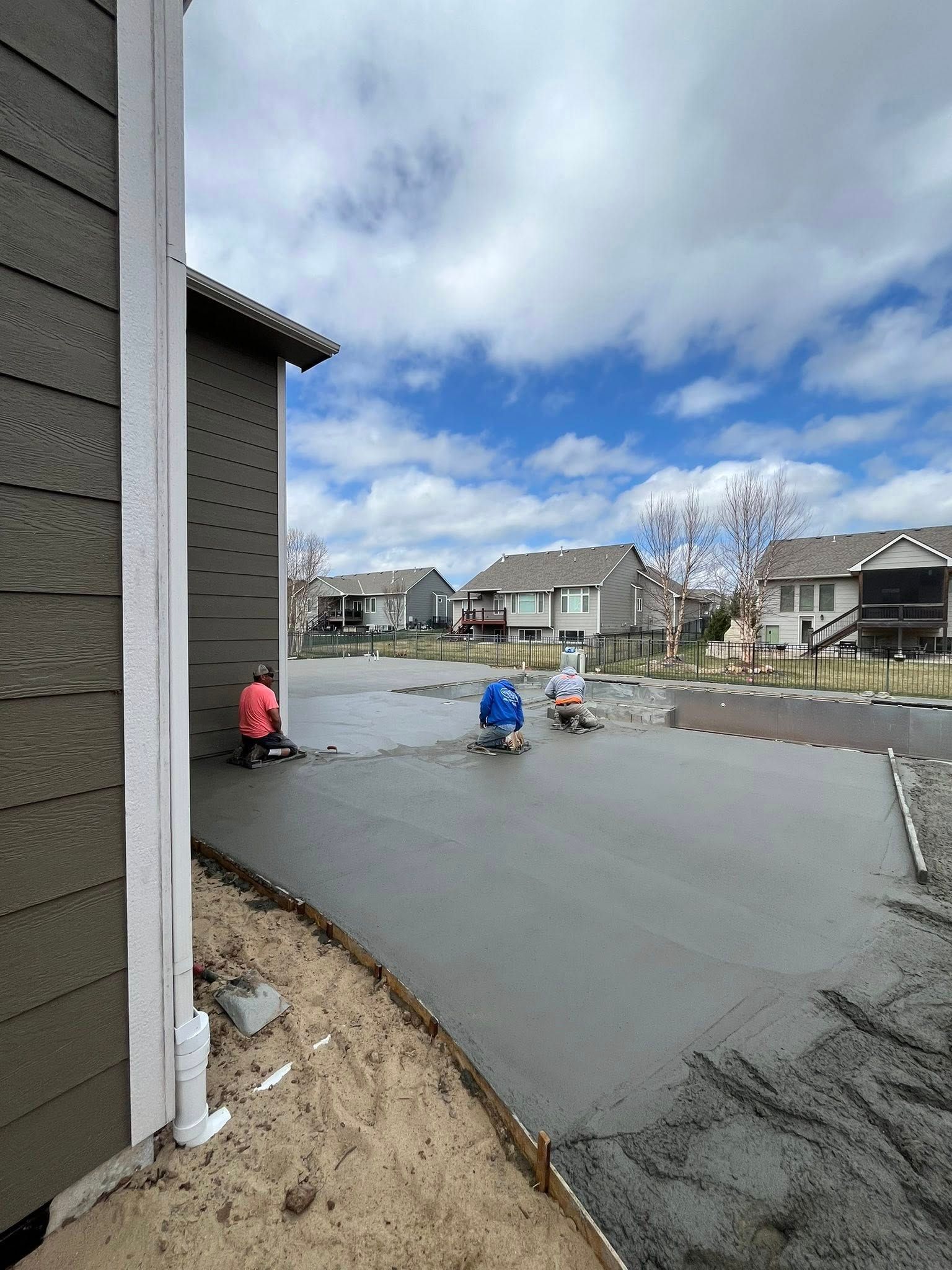 A concrete driveway is being poured in front of a house.