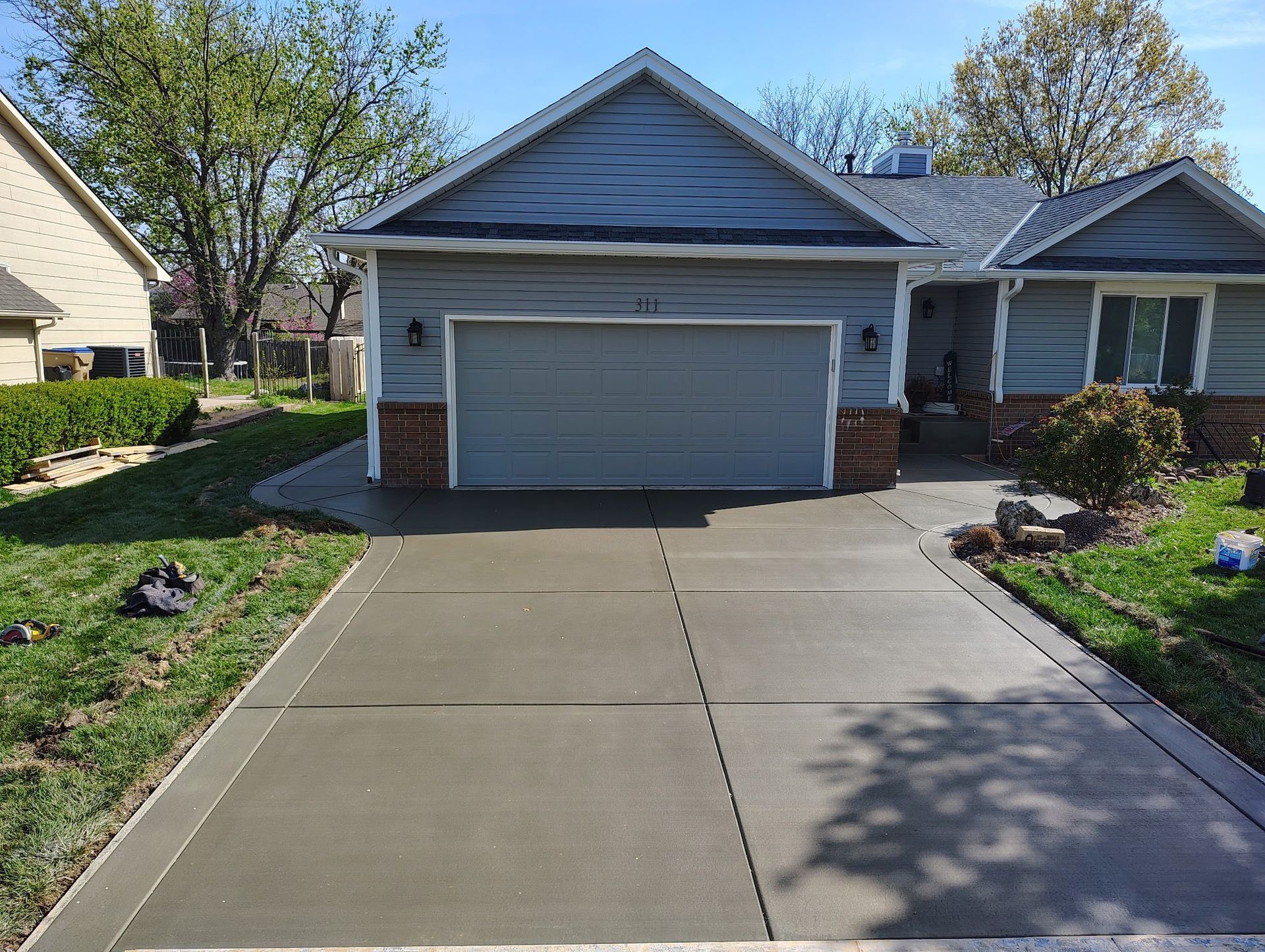 A house with a garage and a concrete driveway in front of it.