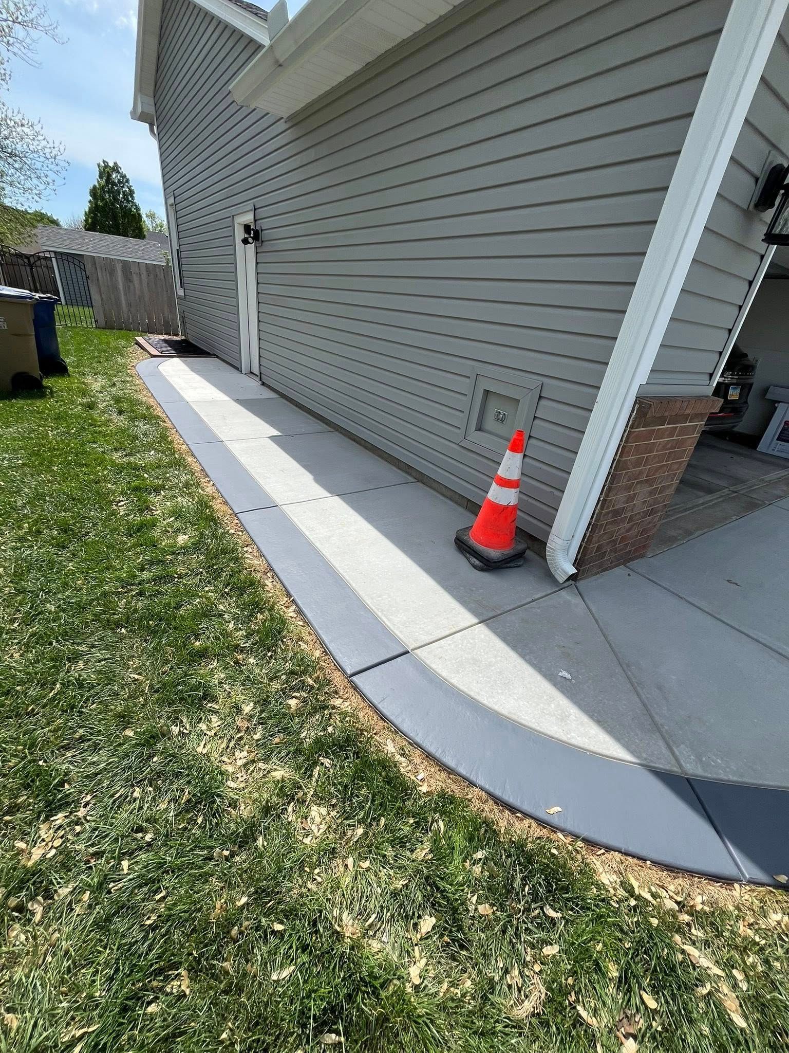 A concrete sidewalk is being installed in front of a house.